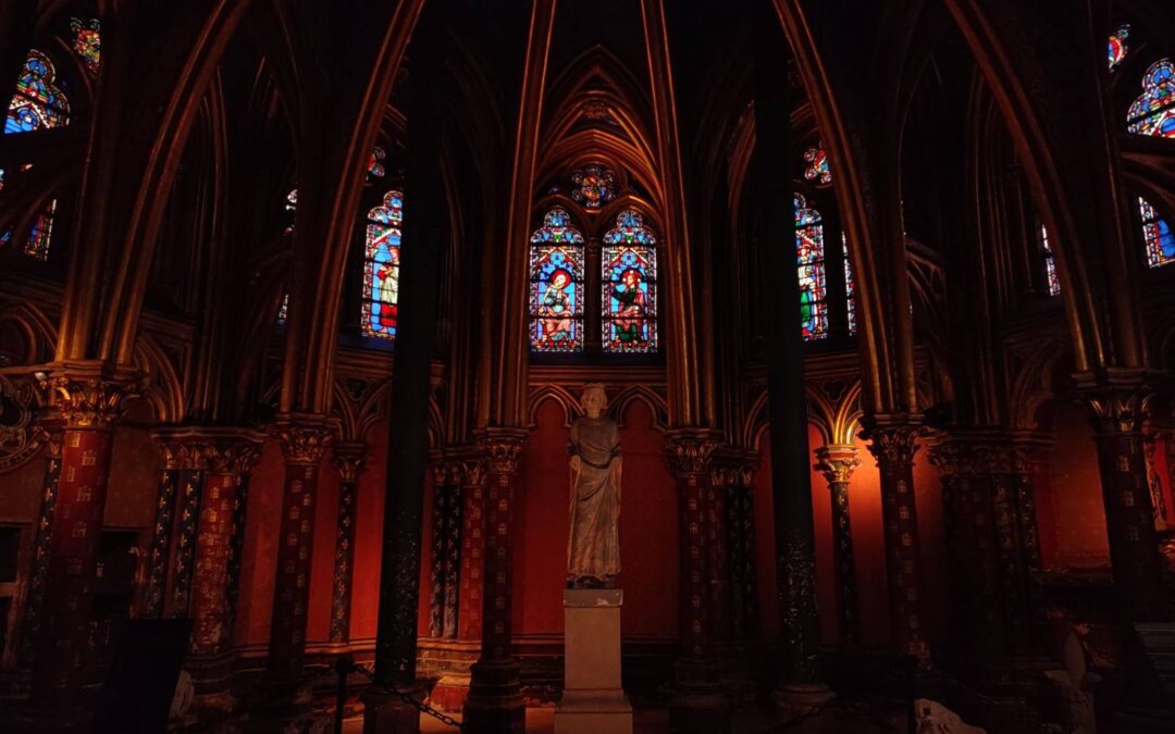 Gothic interior of Sainte-Chapelle in Paris with vibrant stained glass windows and sculptures.
